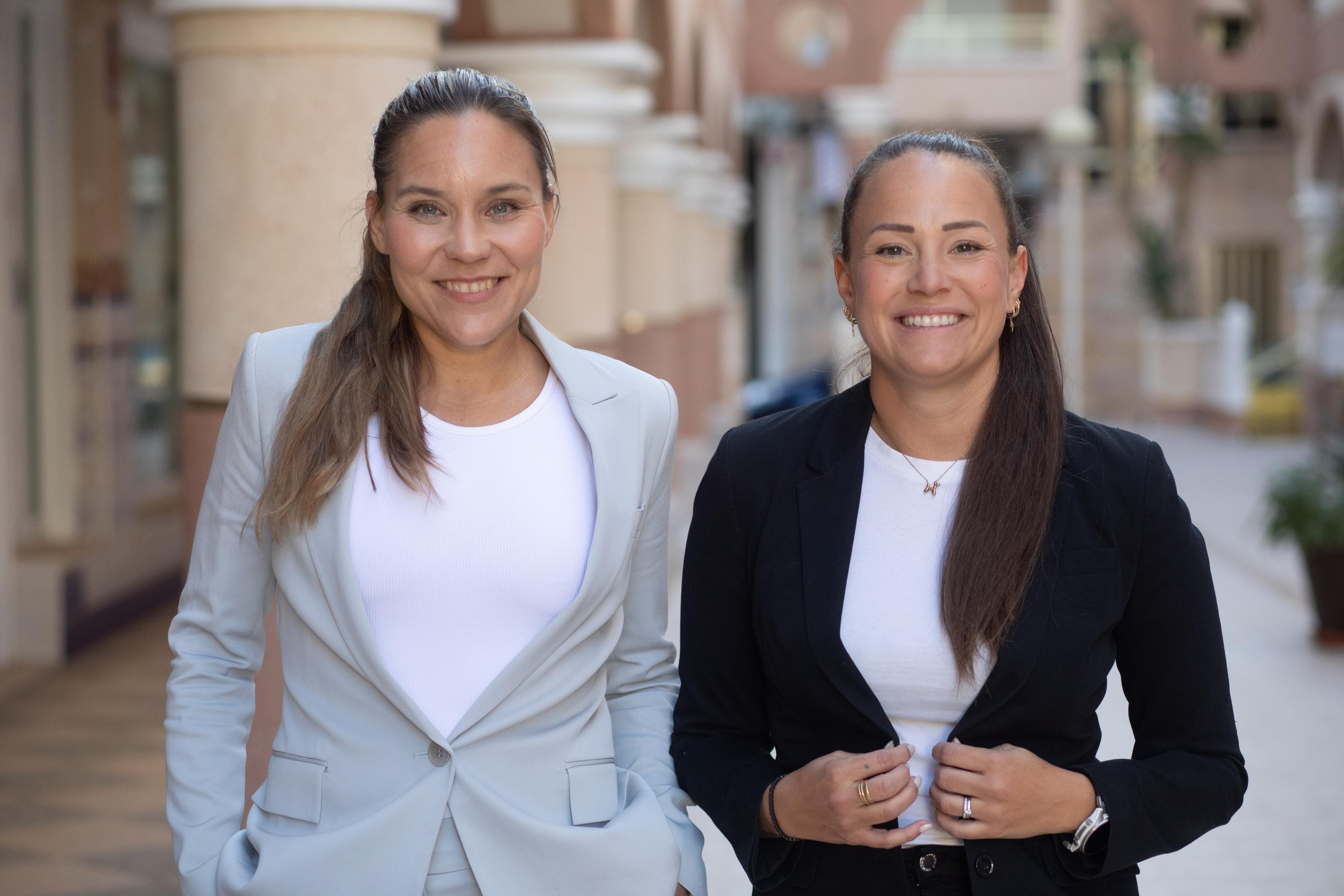 Två affärspartners skakar hand med leenden, symboliserande ett varmt och tryggt samarbete som stärker företagande och ekonomi.